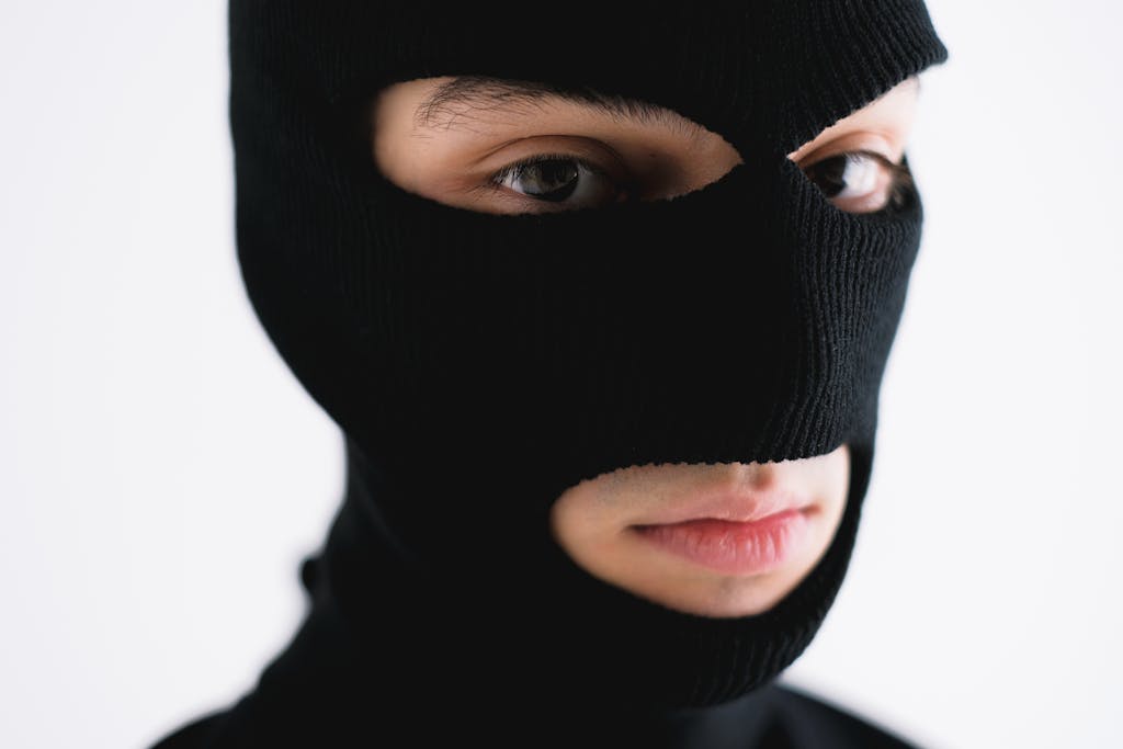 Close-up of a person wearing a black balaclava, conveying mystery or anonymity.