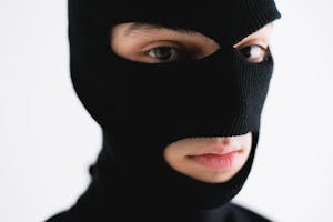 Close-up of a person wearing a black balaclava, conveying mystery or anonymity.